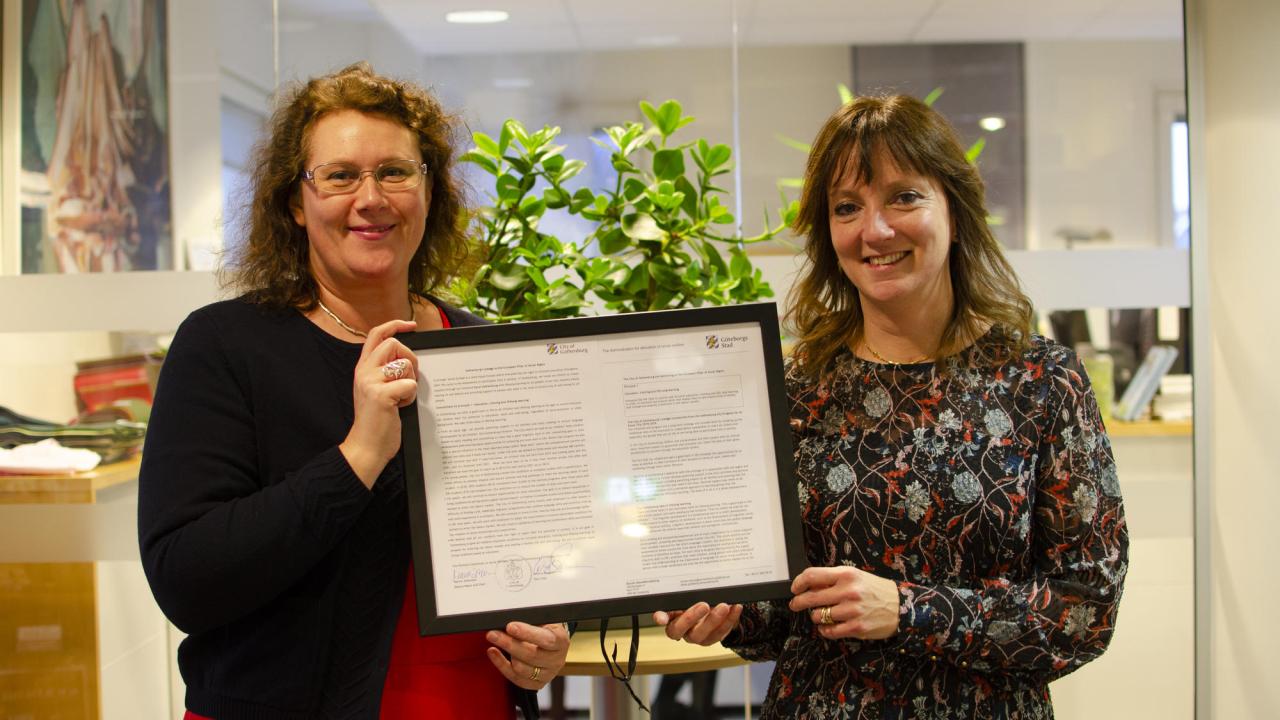 Kristina Bergman Alme (L) och Marina Johansson (S) visar upp dokumentet som visar att Göteborg lovat jobba med utbildning och livslångt lärande inom ramen för det sociala protokollet.