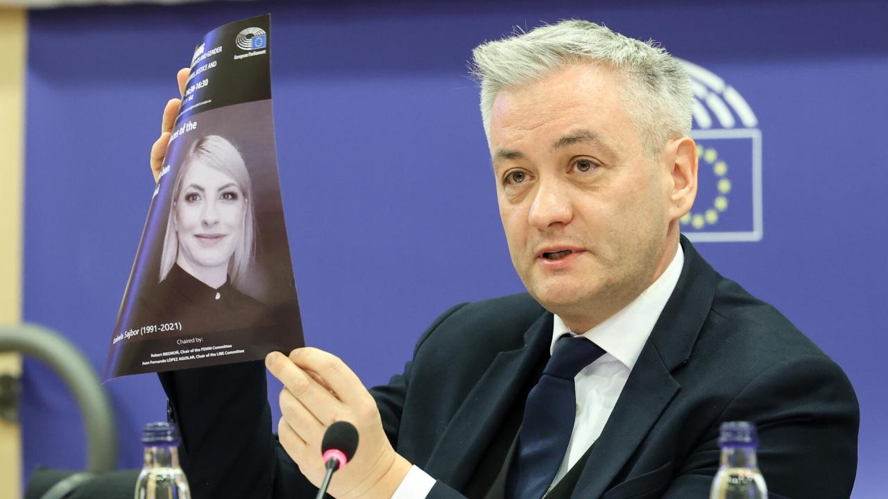 Den polske EU-parlamentarikern Robert Biedrón (S) håller upp en bild av Izabela Sajbor som 2021 avled efter att läkarna inväntat att hennes foster skulle dö av sig själv innan man satte in livsräddande insatser för att försöka rädda hennes liv. "Det första kända offret för abortförbudet i Polen", enligt Biedrón. 